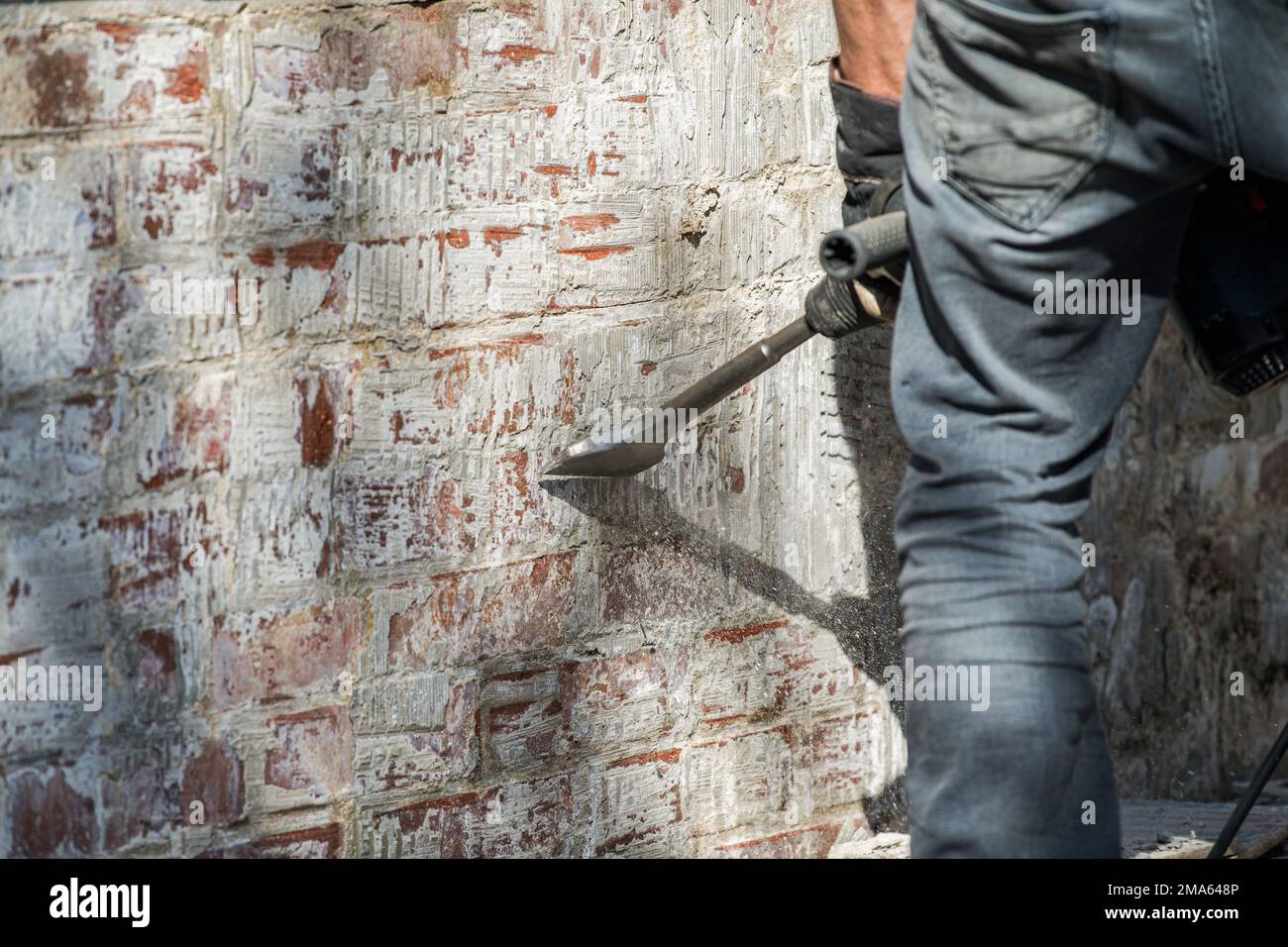 Man removes tiles from a wall with a hammer drill Stock Photo Alamy