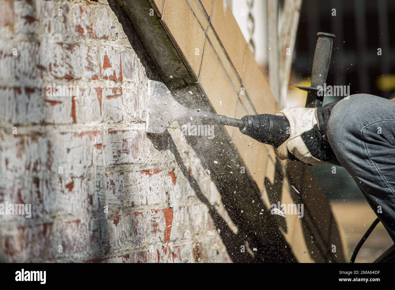 Man removes tiles from a wall with a hammer drill Stock Photo Alamy