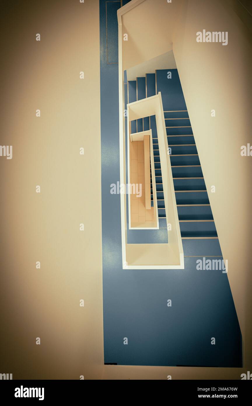 Staircase with white banister and blue vinyl floor from top to bottom