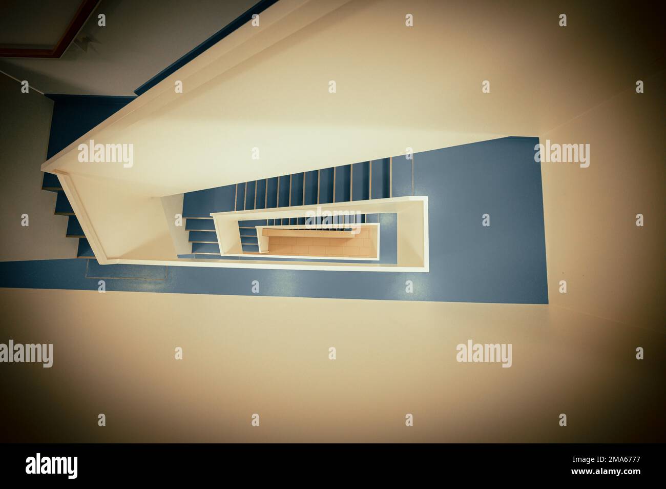 Staircase with white banister and blue vinyl floor from top to bottom