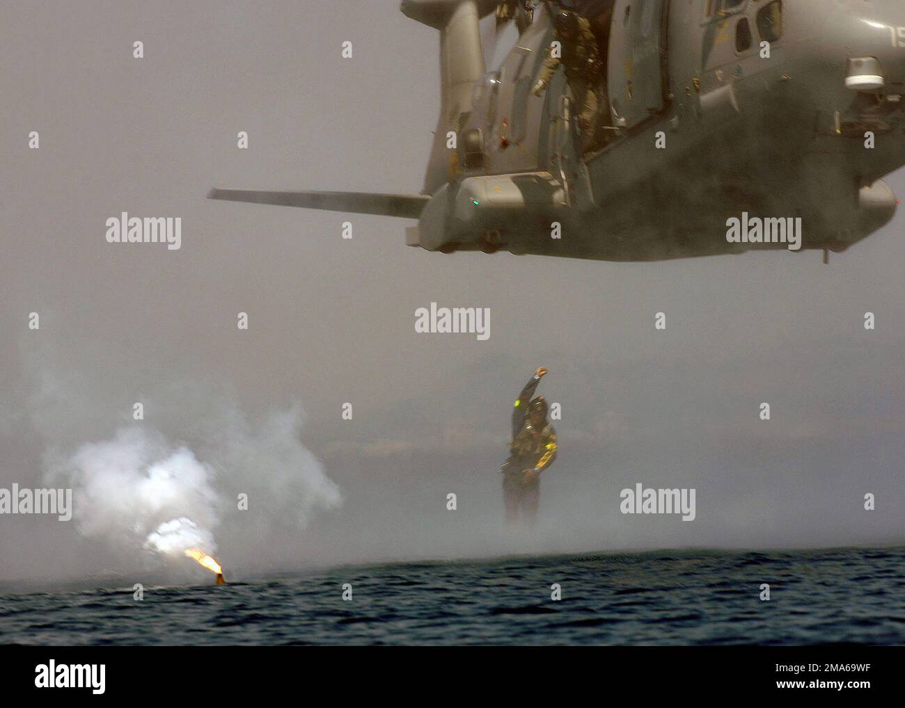 050624-N-1464F-036. [Complete] Scene Caption: A diver assigned to the Italian Submarine Parachute Advisory Group (SPAG) jumps out of a Marina Militare EH-101 Shark helicopter to assist Sailors that escaped from their submarine, in Submarine Escape and Immersion Equipment (SEIE) MK-10 suits, during the North Atlantic Treaty Organization (NATO) Submarine Escape and Rescue (SERS) Exercise SORBET ROYAL 2005. Divers from various nations will work together to rescue submariners during the exercise in the Mediterranean. Twenty-seven participating nations, including 14 NATO nations will test their cap Stock Photo
