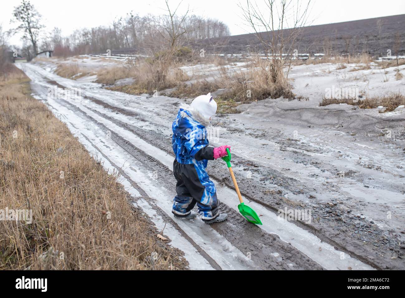 The child helps to bury the pits of dug cars on the road. Caring for a