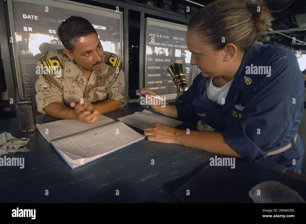 050704-N-4309A-418. [Complete] Scene Caption: US Navy (USN) SENIOR CHIEF Quartermaster (QMCS) Amy Coppedge gives navigation training to an Iraqi Navy officer aboard the USN Whidbey Island Class Dock Landing Ship USS ASHLAND (LSD 48). The Iraqi Navy and Marines are training with the Maritime Riverine Assistant Support Troop, comprised of Royal Navy and Royal Marines. The Iraqi military is afforded an opportunity to train aboard USN ships, because their country is not equipped with the proper platforms for certain training purposes. Maritime Riverine Assistant Support Troop and the Ashland are a Stock Photo