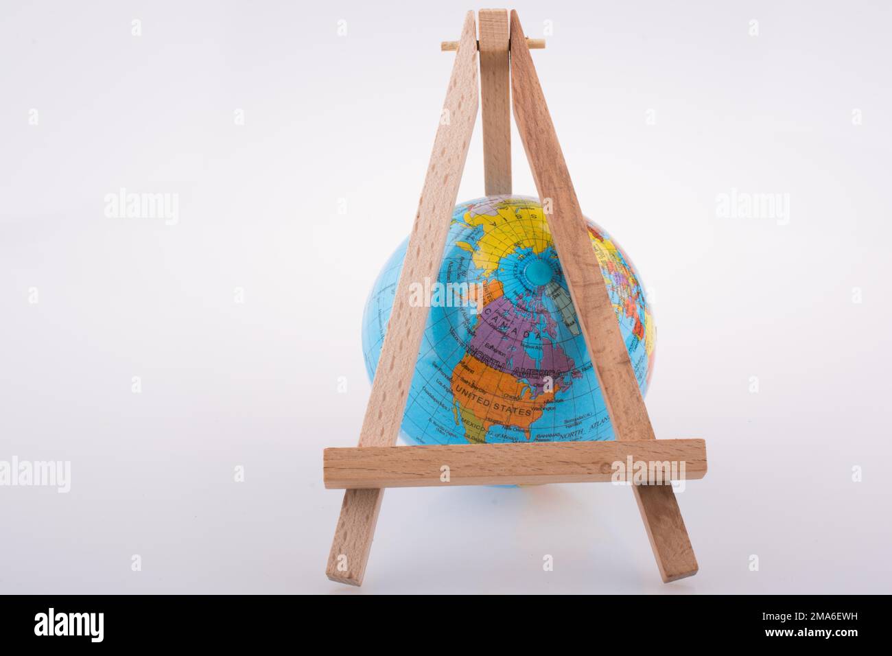 Little model globe put under tripod on a white background Stock Photo