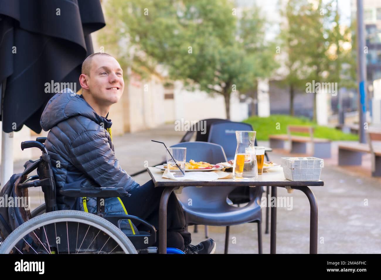 A disabled person eating on the terrace of a restaurant Stock Photo