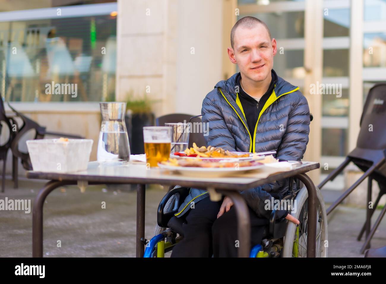 A disabled person in a wheelchair in a restaurant waiting to eat Stock