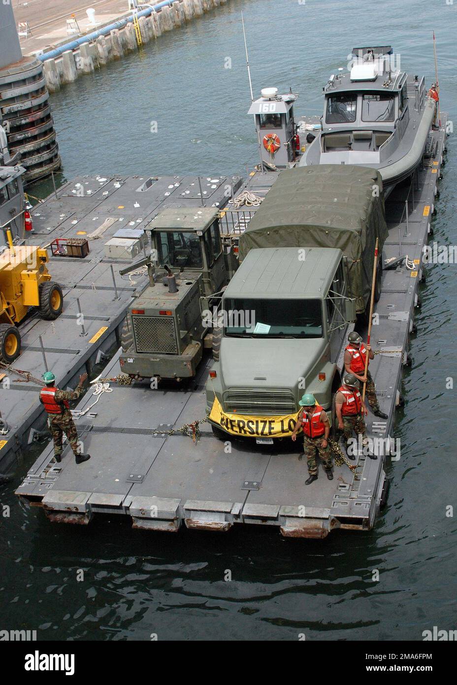 US Navy (USN) Seabees, assigned to Amphibious Construction Battalion One (ACB-1), prepare to off load equipment from a cargo lighter to a heavy lift ship, in the harbor at San Diego, California (CA). Base: San Diego State: California (CA) Country: United States Of America (USA) Stock Photo