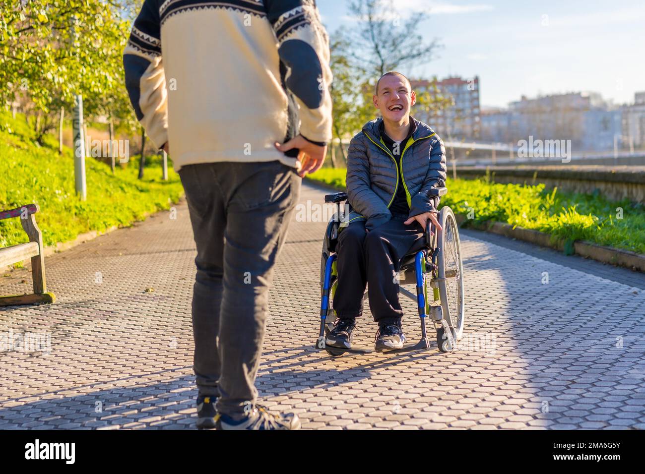 Disabled person in a wheelchair smiling with a family member taking a