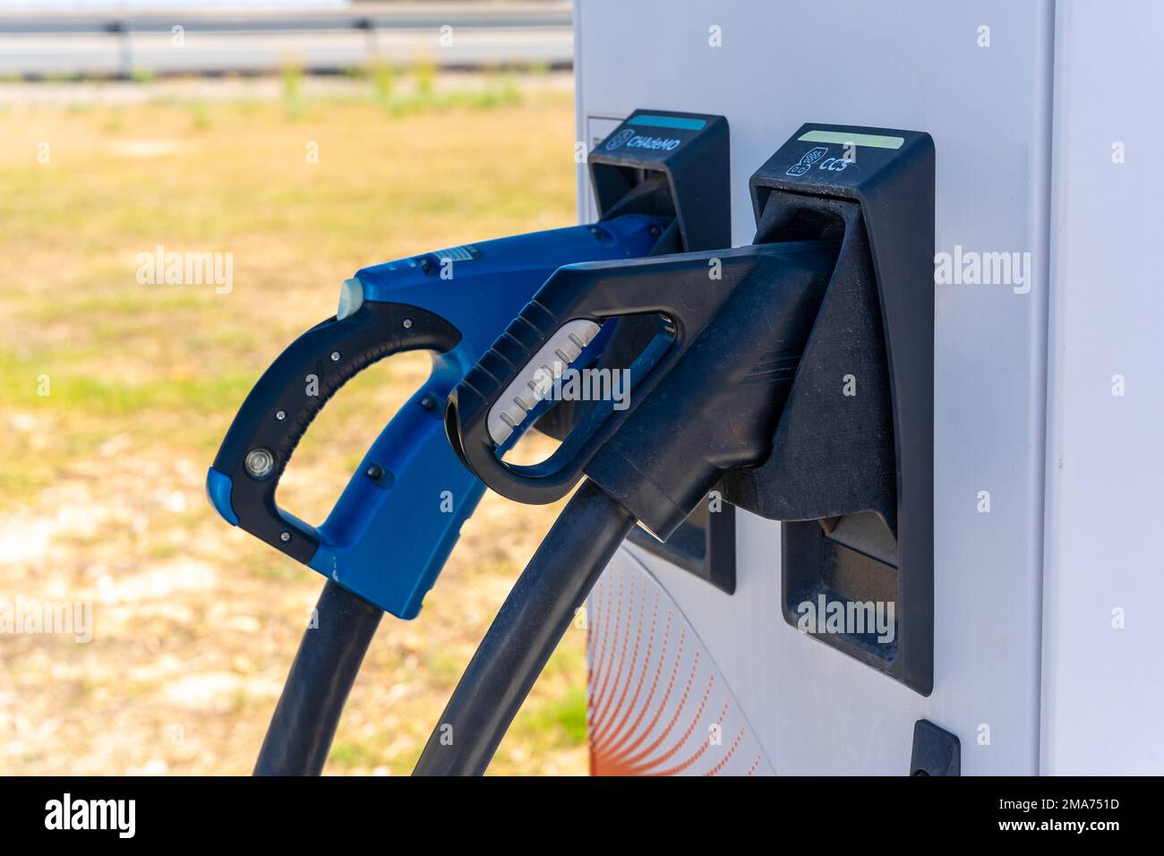 Electric car chargers at a gas station, with a parking space