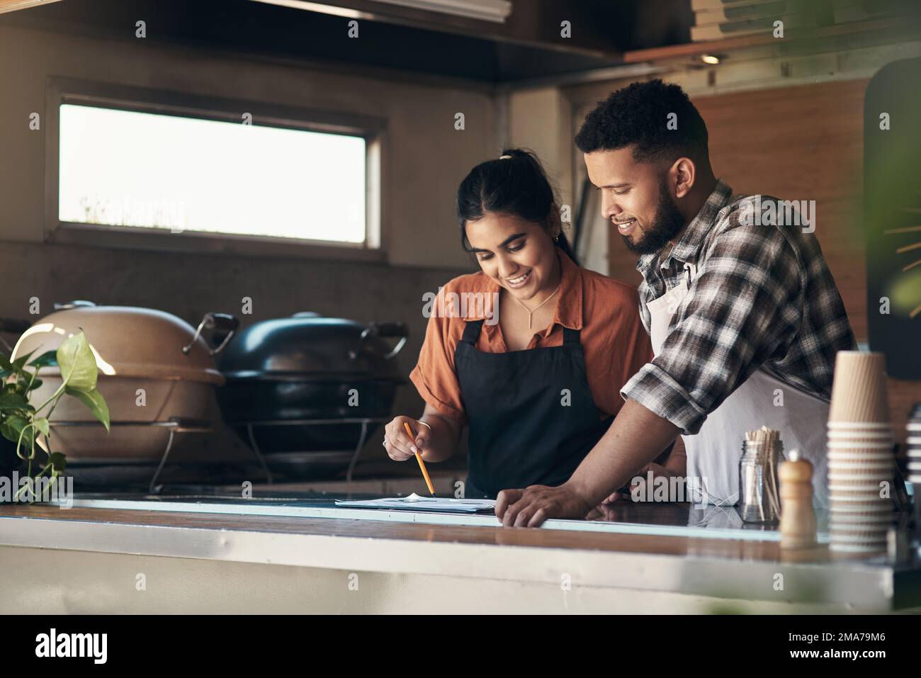 I really love this combination of flavours. two young restaurant owners standing inside together and planning their menu. Stock Photo