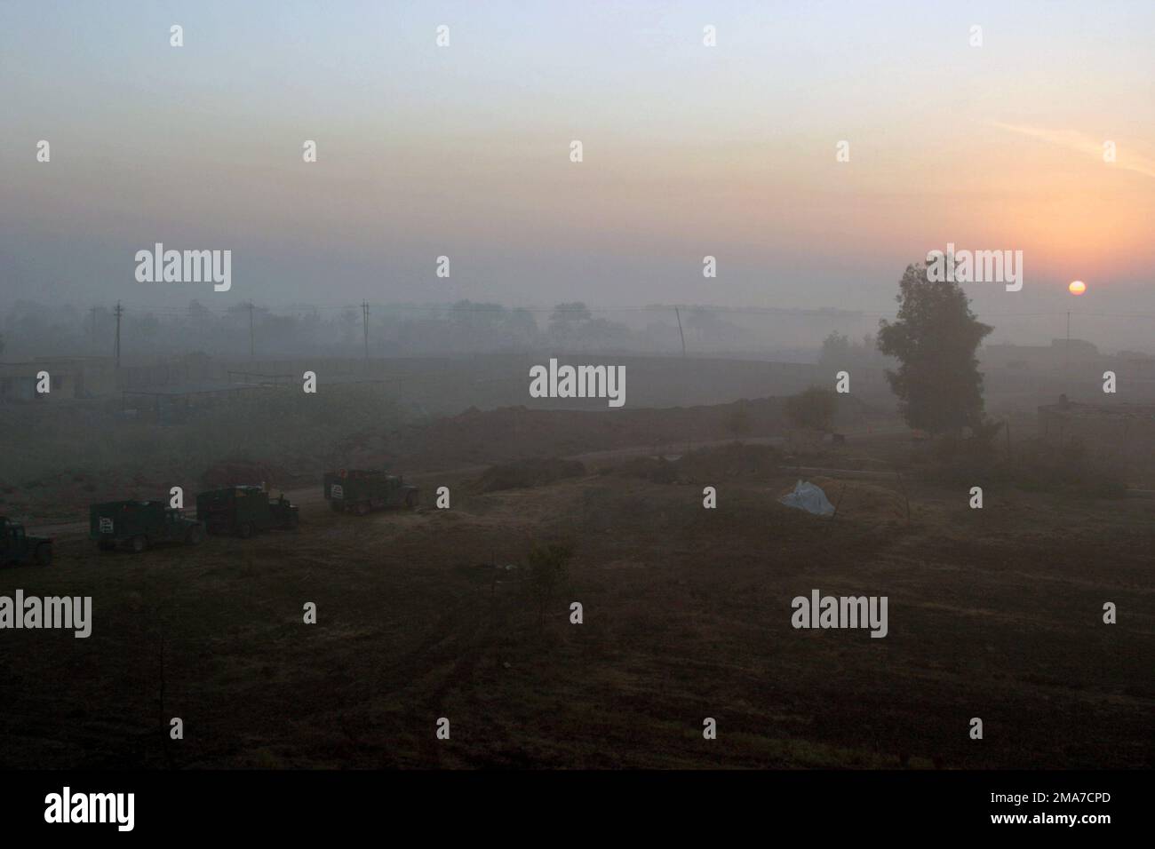 The US Marine Corps (USMC) vehicles of Echo Company (E CO), 2nd Battalion (BN), 2nd Marines, sit outside of a Forward Operations Base (FOB) in the early morning fog as they prepare for Operation Trifecta in Zaidon, Iraq, under Operation IRAQI FREEDOM. Where the goal, to clear out anti-Iraqi forces and to prevent them from using the city in the future. Base: Zaidon State: Al Anbar Country: Iraq (IRQ) Stock Photo