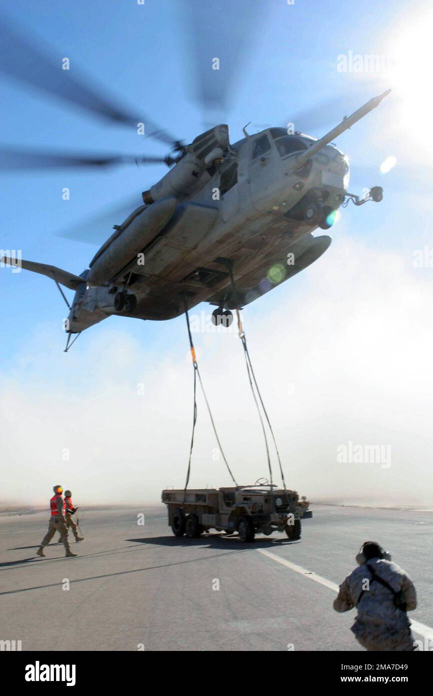 US Marine Corps (USMC) landing support Marines move back after hooking up a broken M-939A2 5-ton truck to a USMC CH-53 Super Stallion helicopter from Marine Heavy Lift Squadron 466 (HMH-466), Naval Air Station (NAS) Miramar, California (CA), at Al Asad Air Base (AB), Iraq, during Operation IRAQI FREEDOM. The truck is being moved to another area of the base for heavy lift training. Base: Al Asad State: Al Anbar Country: Iraq (IRQ) Stock Photo