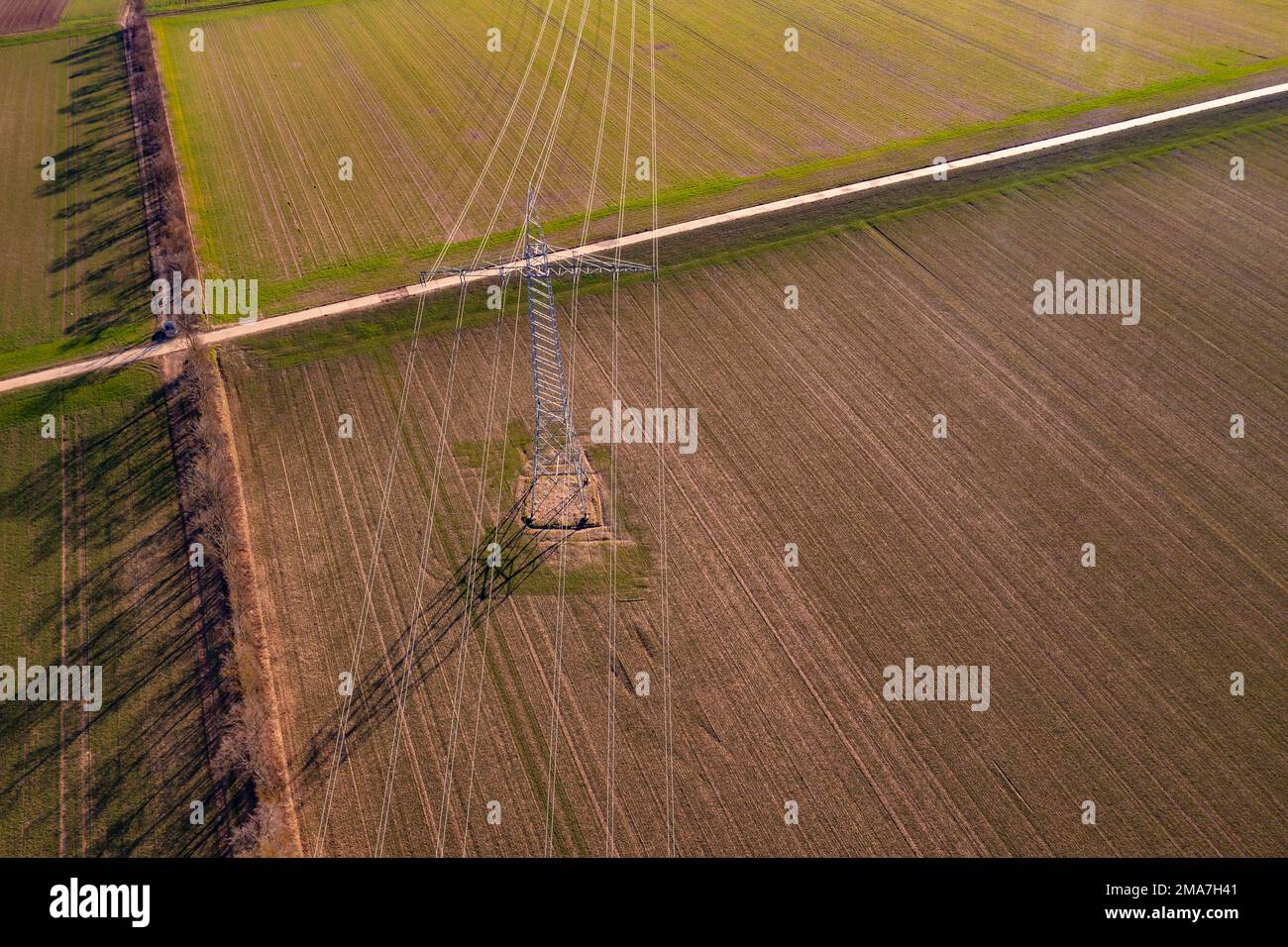 Aerial view of power lines on a high voltage pylon in a rural field Stock Photo