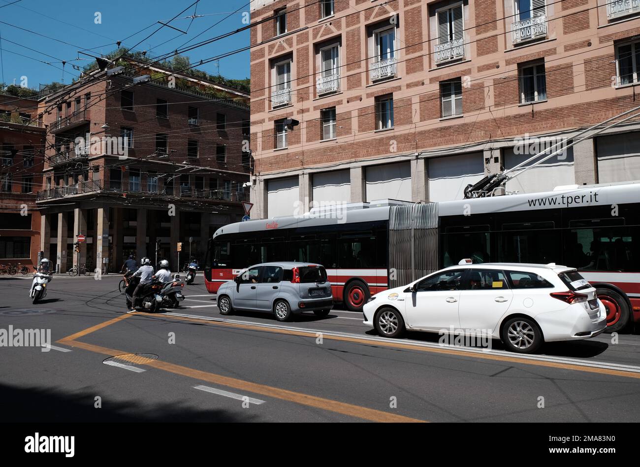 Cars, bus tram and motorcycles wait at a road junction in Bologna in Northern Italy. Stock Photo