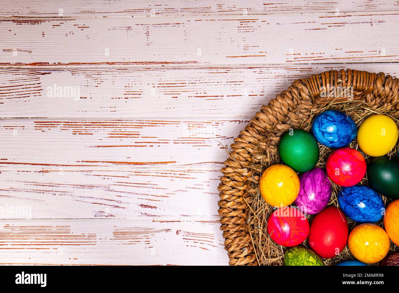 Tabletop easter theme with copy space. Colorful easter eggs with basket  Stock Photo