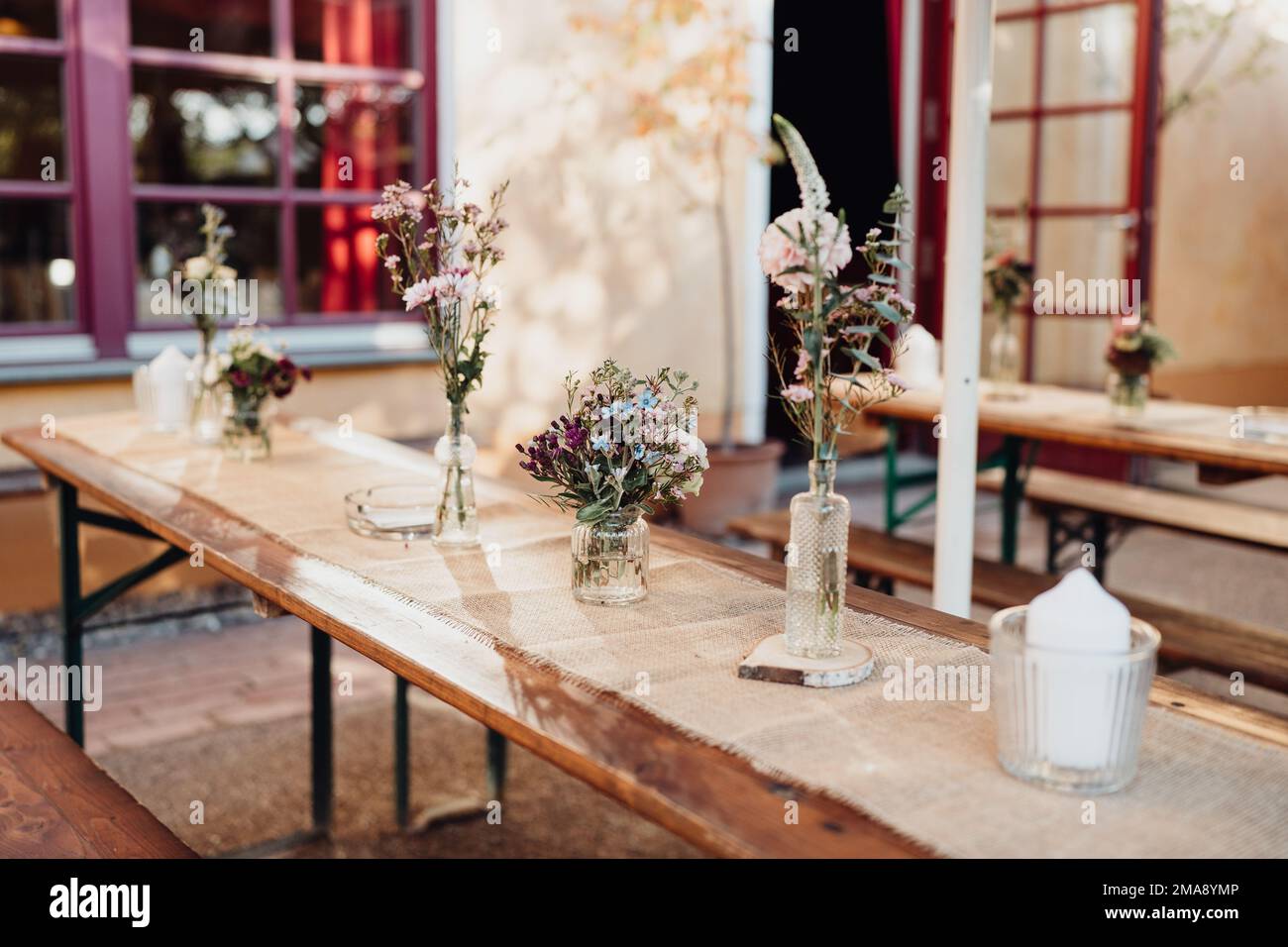 Bunte Blumen und Kerzen auf gedecktem Hochzeitstisch Stock Photo