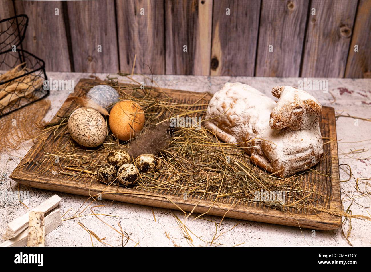 Easter lamb made of cake with colorful Easter eggs on straw, still life Stock Photo