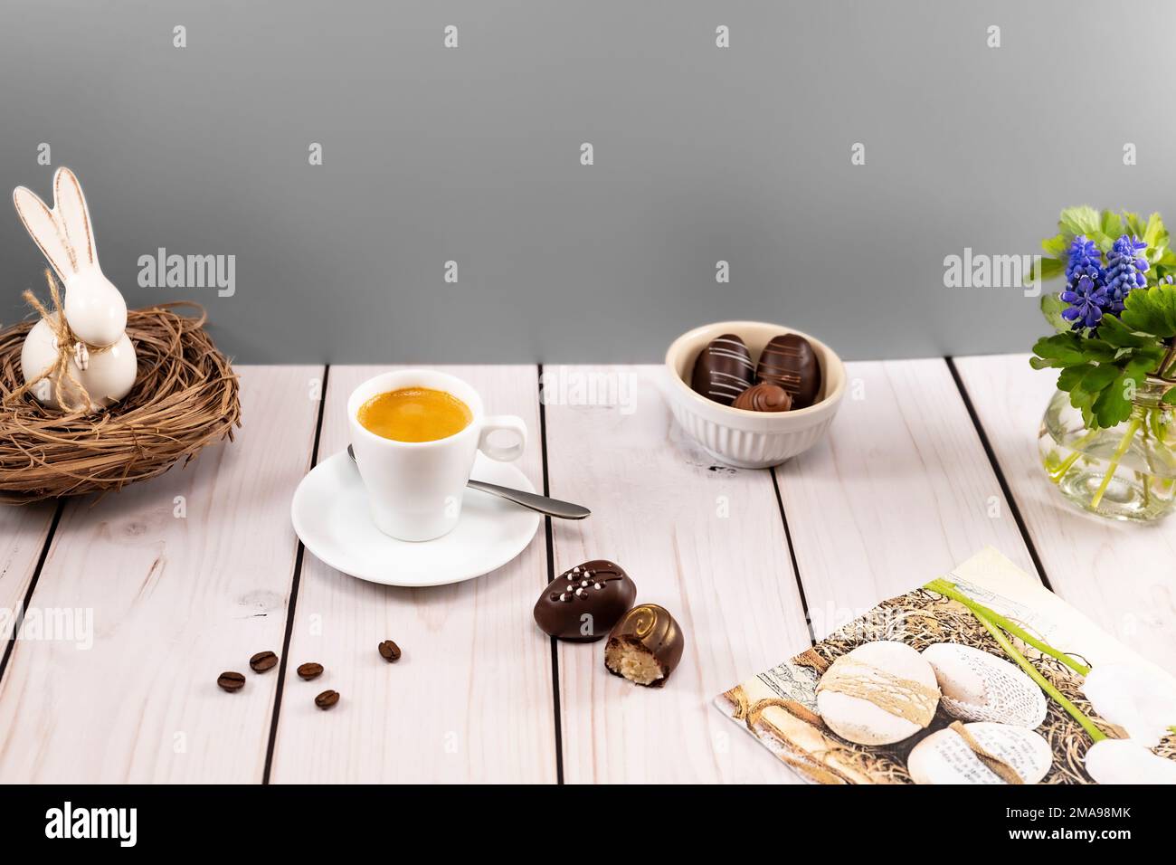 Decorated easter egg chocolates with espresso at set table Stock Photo