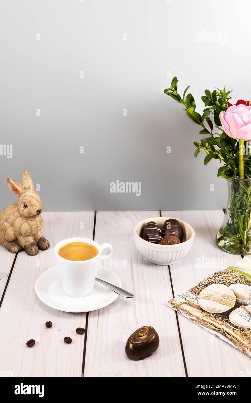 Decorated easter egg chocolates with espresso at set table Stock Photo