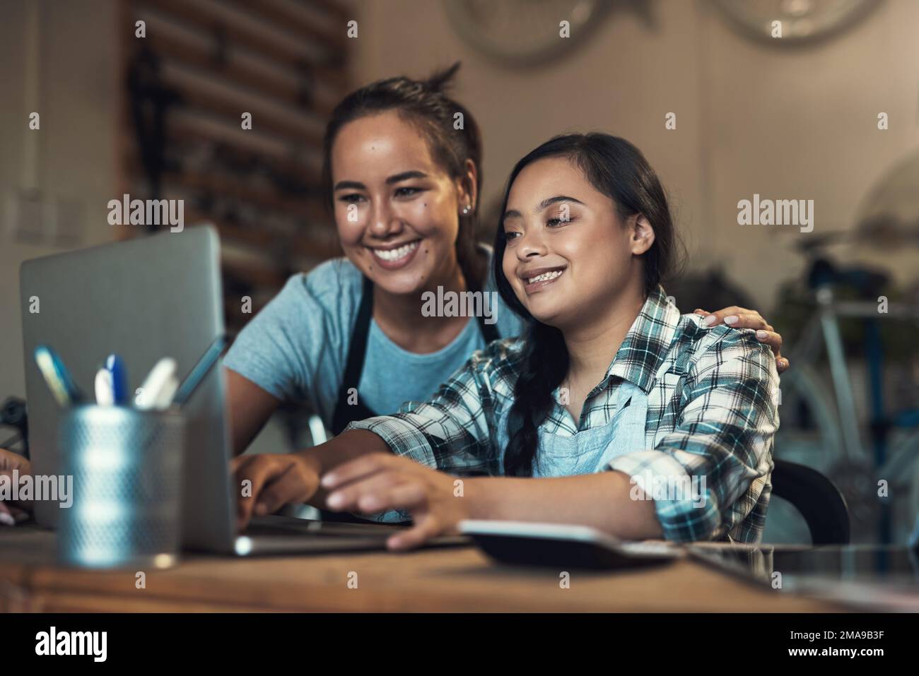 Id rather stay where I grow. two young workers using a laptop at work. Stock Photo