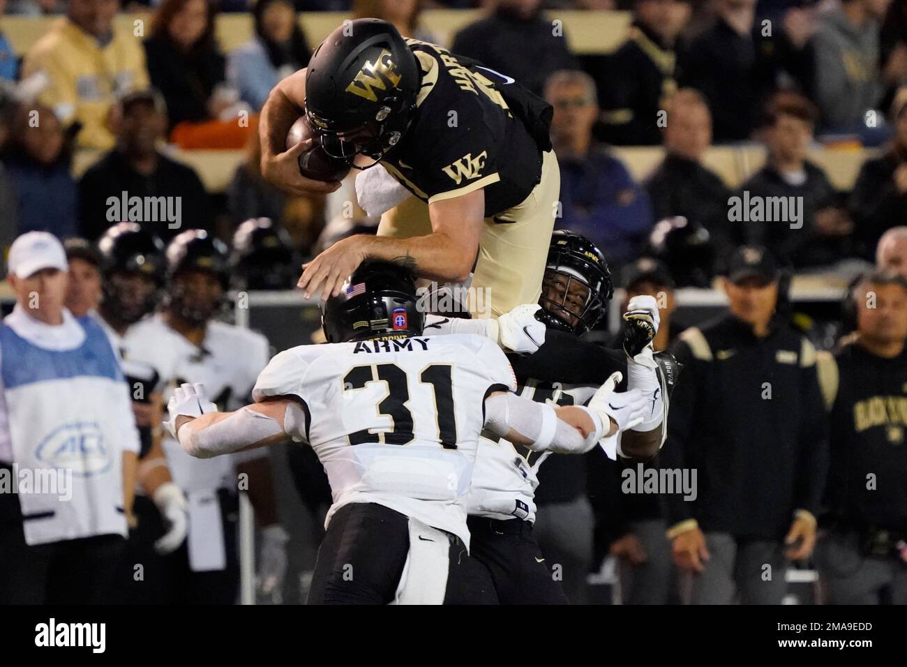 Wake Forest's Sam Hartman (10) tries to leap over Army's Leo Lowin (31