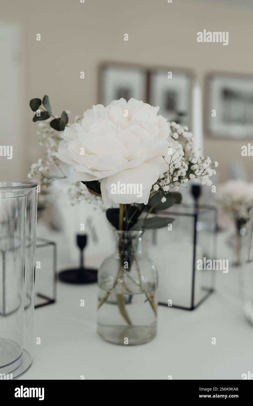 Blumen und Kerzen auf gedecktem Hochzeitstisch Stock Photo