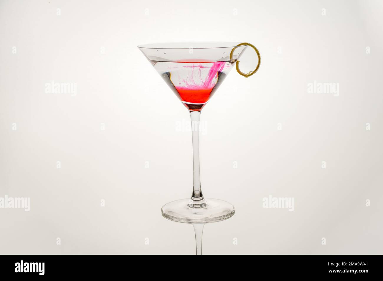 pink lemonade gin cocktail with a lemon twist isolated on a white background Stock Photo Alamy