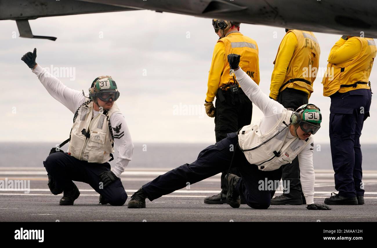 Flight deck officers signal launch control during flight training ops