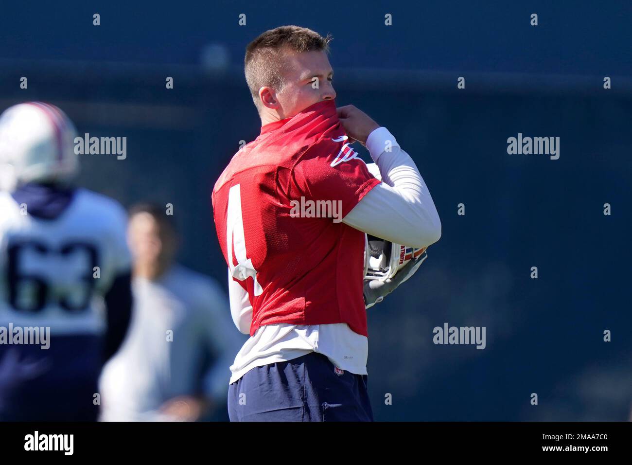 New England Patriots quarterback Bailey Zappe wipes his face during an