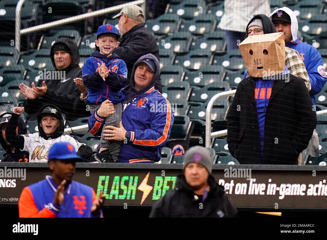 New York Mets fans, one wearing a paper bag over their head, watch