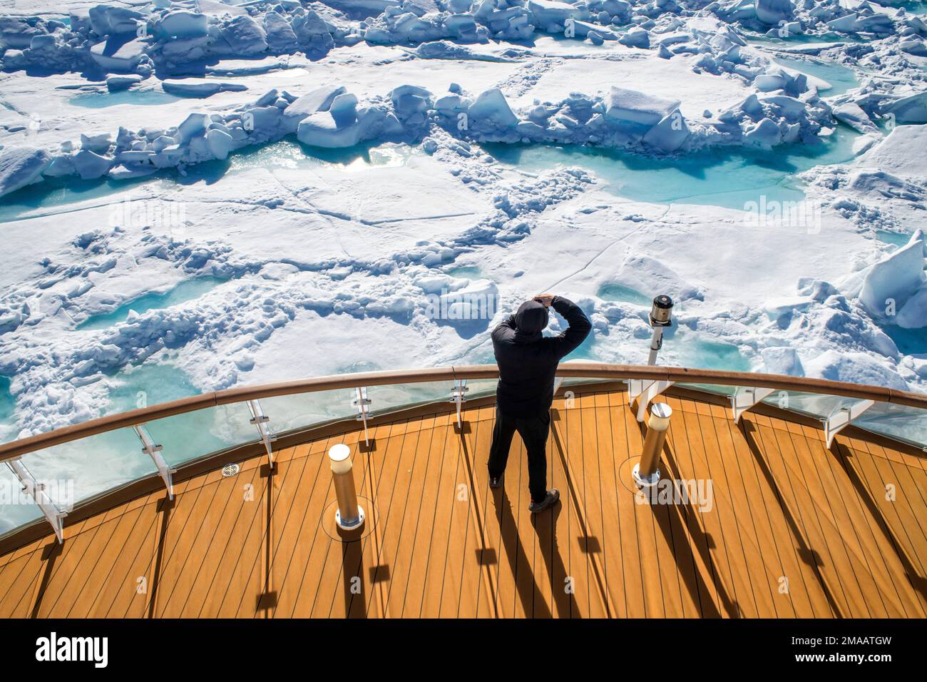 Tourist taken pictures in the main deck of the expedition cruise vessel Greg Mortimer in Svalbard archipelago, Arctic Norway. Stock Photo