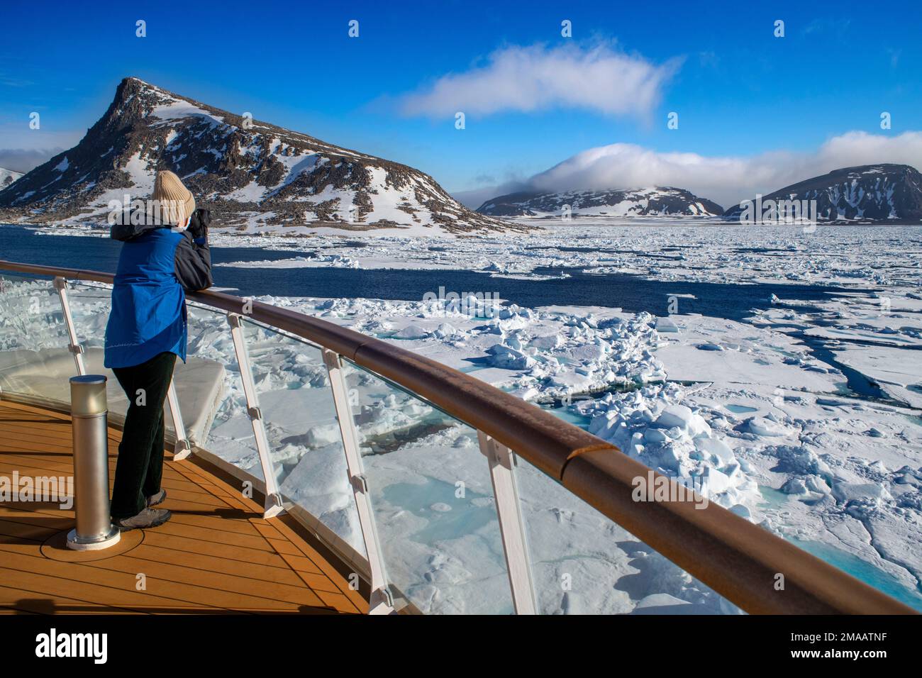 Tourist taken pictures in the main deck of the expedition cruise vessel Greg Mortimer in Svalbard archipelago, Arctic Norway. Stock Photo