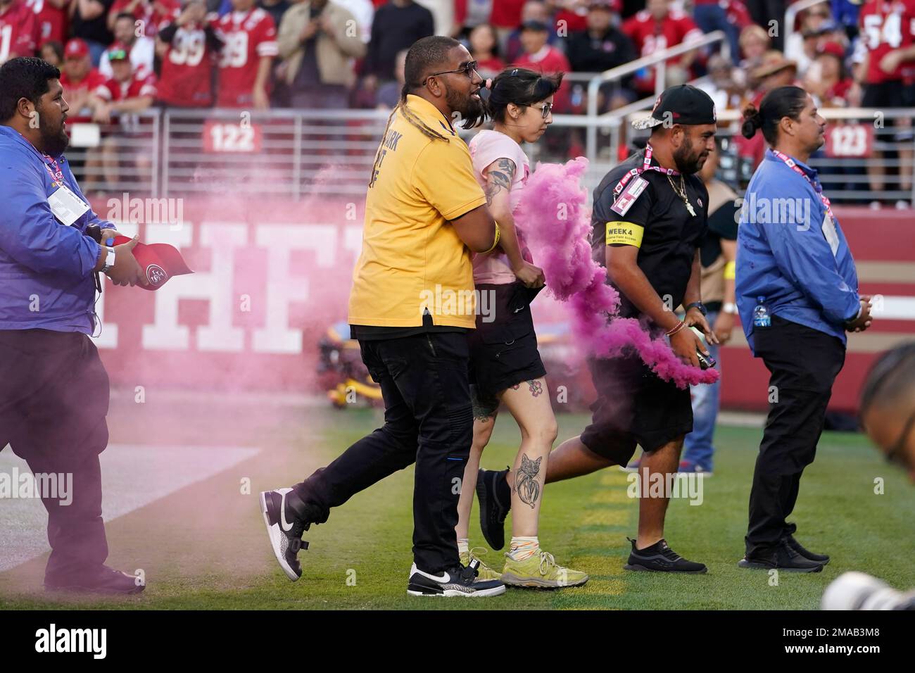 Security escorts a fan off the field during the first half of an NFL  football game between the San Francisco 49ers and the Los Angeles Rams in  Santa Clara, Calif., Monday, Oct.