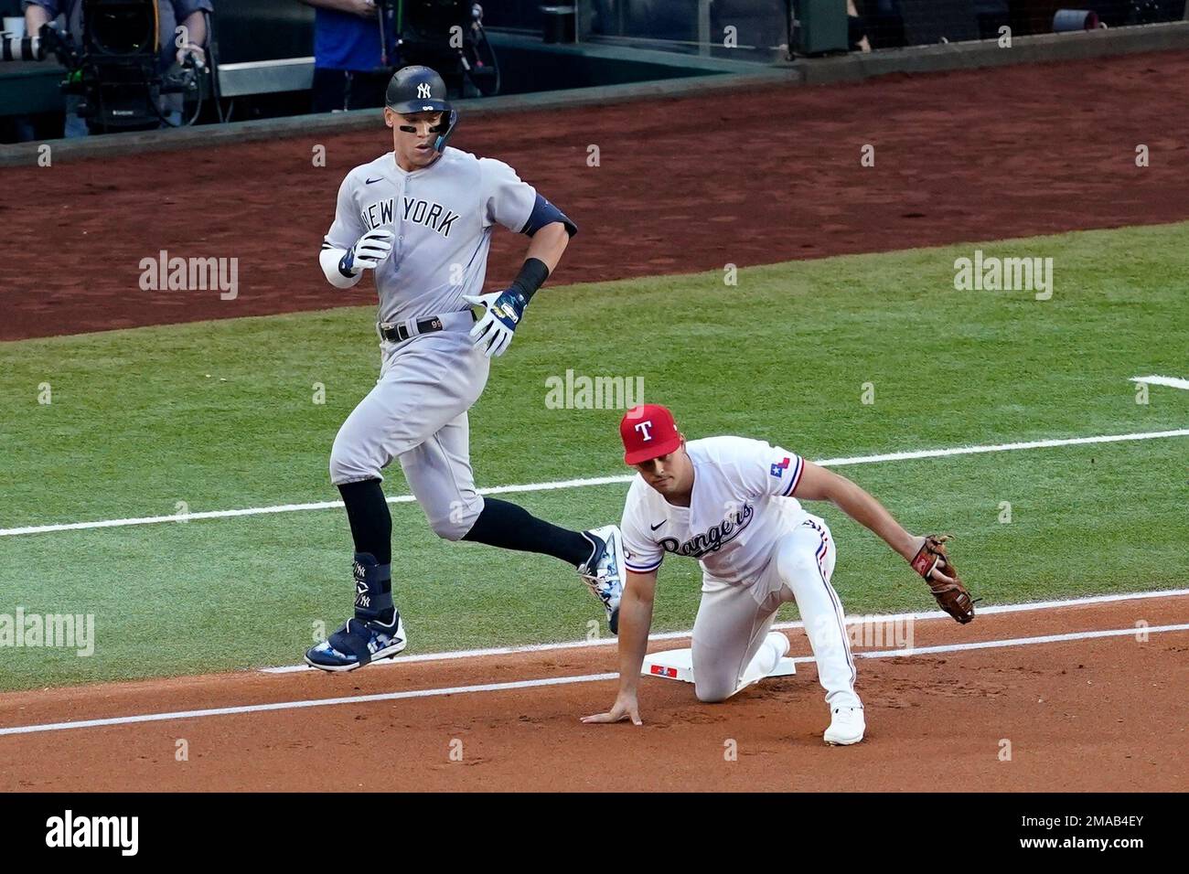 New York Yankees' Aaron Judge, left, looks down to see Texas Rangers ...