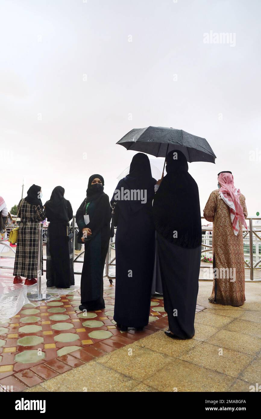 20.02.2021, Saudi Arabia, Riyadh, Riad Arab women standing under an umbrella in the rain