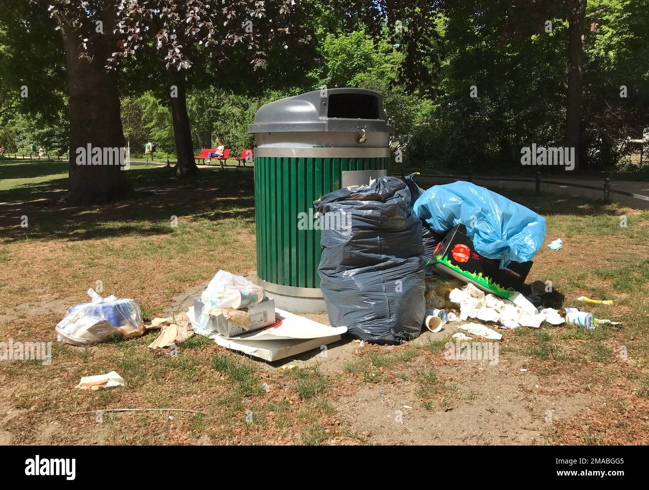 16.05.2022, Germany, , Berlin - Garbage lies in a park next to empty garbage can. 00S220516D062CAROEX.JPG [MODEL RELEASE: NO, MODEL RELEASE: NO (c) ca Stock Photo