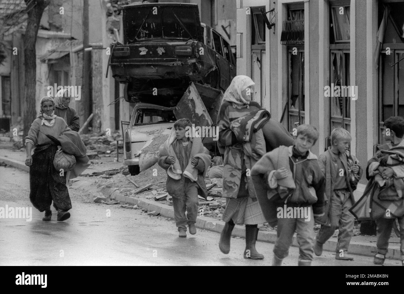 12.10.2022, Bosnia and Herzegovina, Canton Herzegovina-Neretva, Mostar - Bosnian war. End of the first siege of Mostar. Refugees walk with blankets th Stock Photo