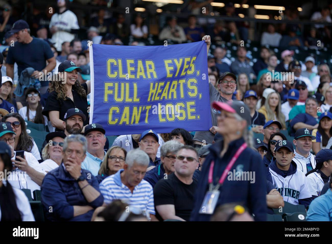 Seattle Mariners fans stand next to a Believe sign during a baseball game  against the Oakland Athletics, Wednesday, Sept. 29, 2021, in Seattle. Fans  and the team have adopted the one-word slogan