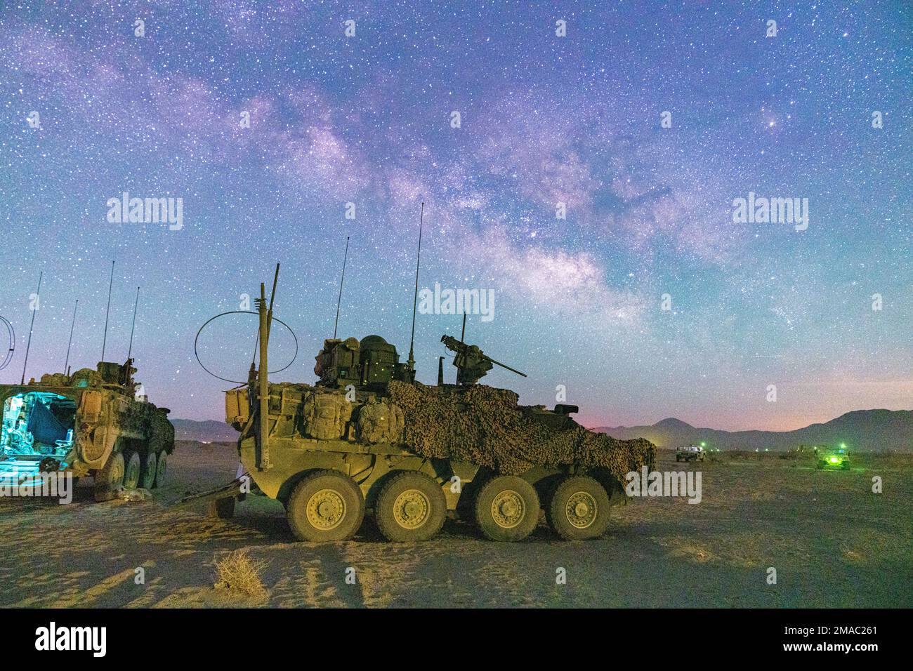 A U.S. Army Stryker assigned to Col. Kevin Bradley, commander of 3d Cavalry Regiment, is parked at a remote location of the National Training Center during a moonless, open sky where the milky way was visible May 24, 2022. Additionally, unmanned aircraft circled the vicinity to monitor for threats and intelligence from the sky. Stock Photo
