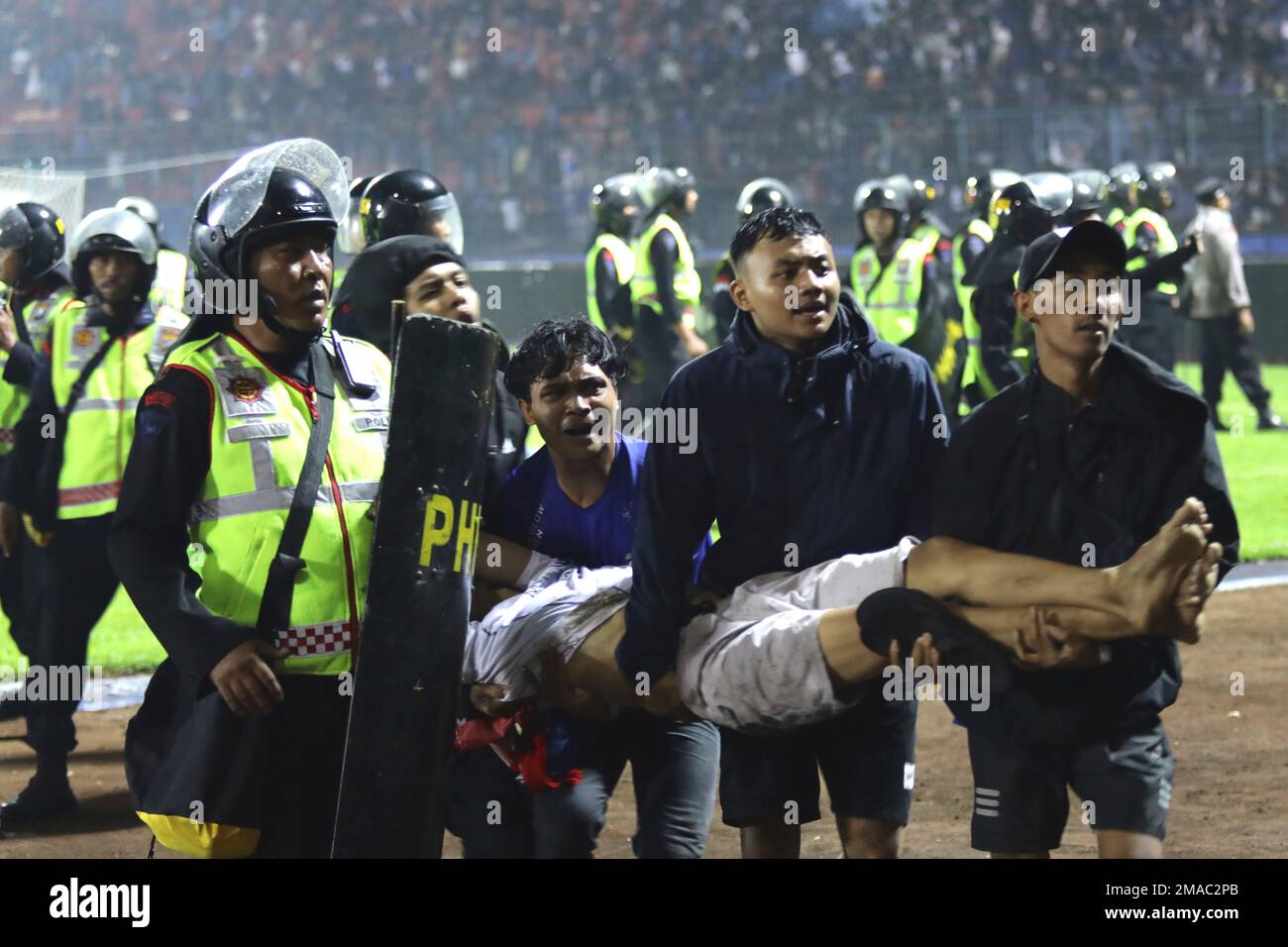 Soccer fans carry an injured man following clashes during a soccer