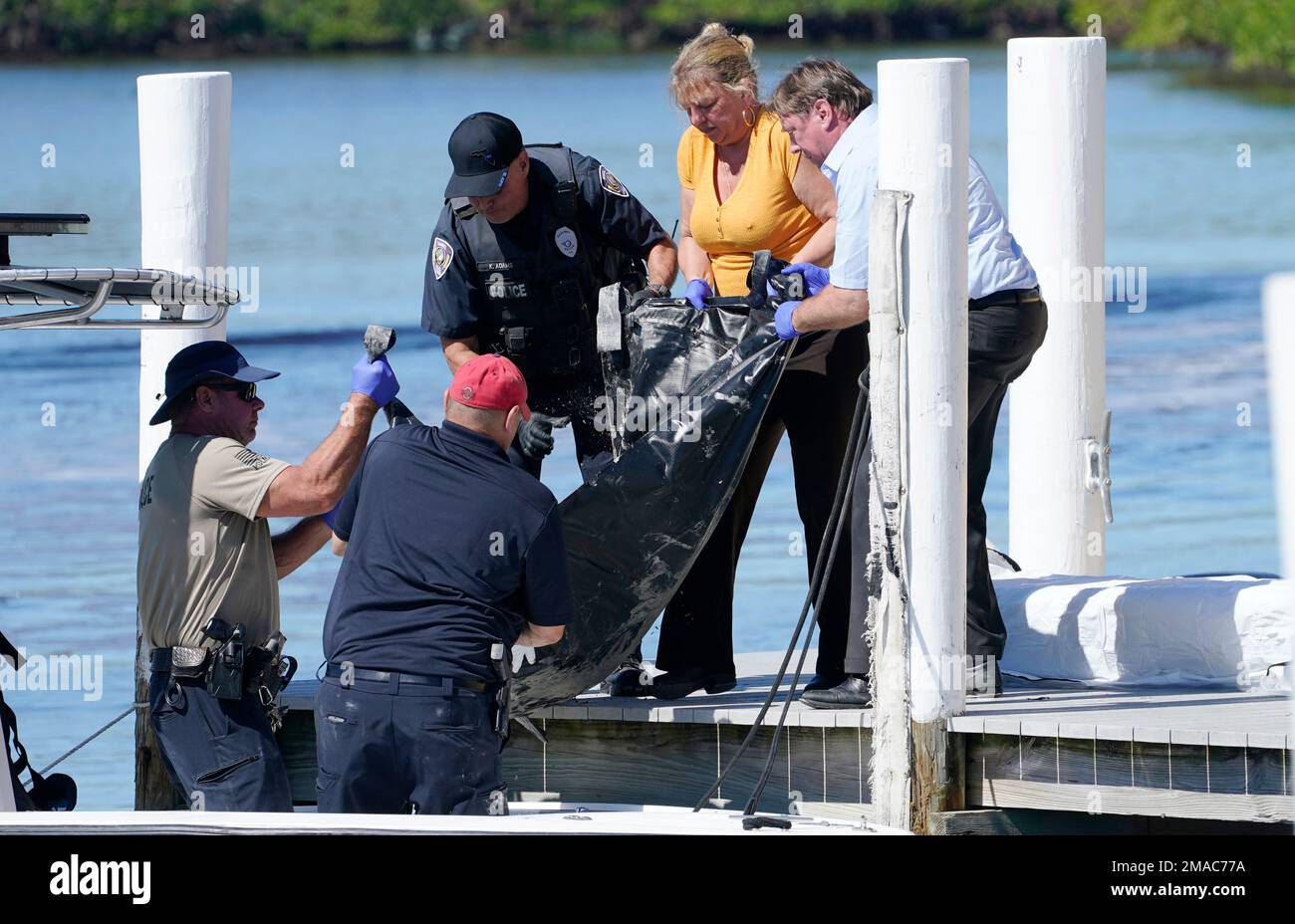 Rescue personnel lift a body recovered from Sanibel Island to a dock ...