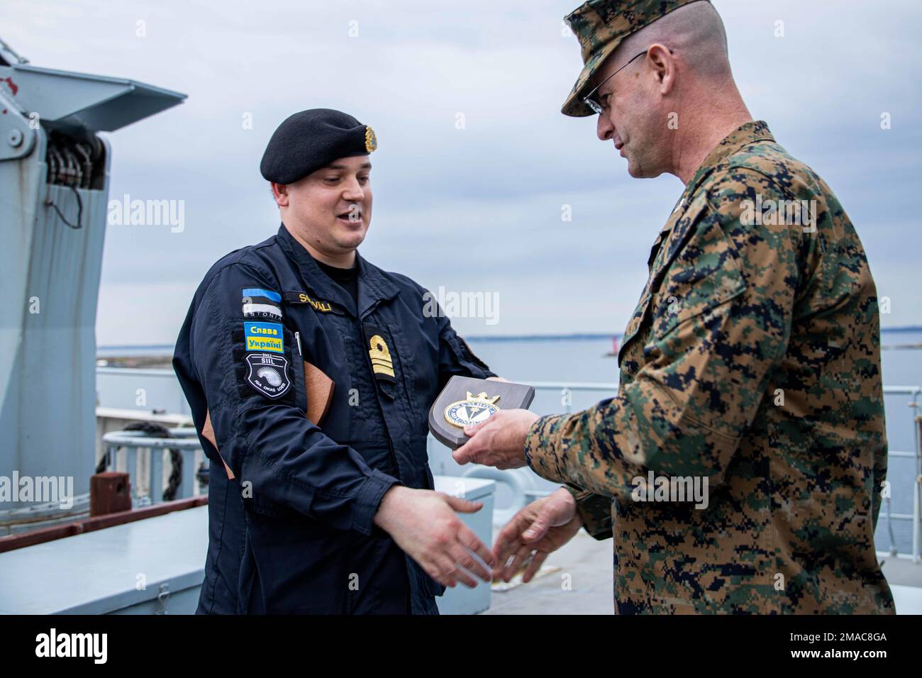 Lieutenant Senior Grade Krister Soovali, captain of the ENS Wambola, presents a gift to Col. Robert Hallett, the Commander of Task Group 61/2.4, the deputy commander for Task Force 61/2, and assistant division commander for 2d Marine Division, aboard the ENS Wambola for the Marine's participation in enhancing Maritime Domain Awareness during Exercise Hedgehog near Tallinn, Estonia, May 25, 2022. Task Group 61/2.4 provides naval and joint force commanders with dedicated multi-domain reconnaissance and counter-reconnaissance (RXR) capabilities. Task Force 61/2 is executing the Commandant of the Stock Photo