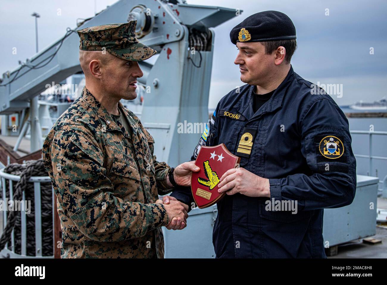 U.S. Marine Corps Lt. Col. Scott Cuomo, commanding officer for 2d Light Armored Reconnaissance Battalion, presents a gift to Lieutenant Senior Grade Krister Soovali, captain of the ENS Wambola, for hosting the Marines of Task Group 61/2.4, during experimentation of Maritime Domain Awareness aboard the ENS Wambola near Tallinn, Estonia, May 25, 2022. Task Group 61/2, Task Force 61/2, provides naval and joint force commanders with dedicated multi-domain reconnaissance and counter-reconnaissance (RXR) capabilities. Task Force 61/2 is executing the Commandant of the Marine Corps’ Concept for Stand Stock Photo