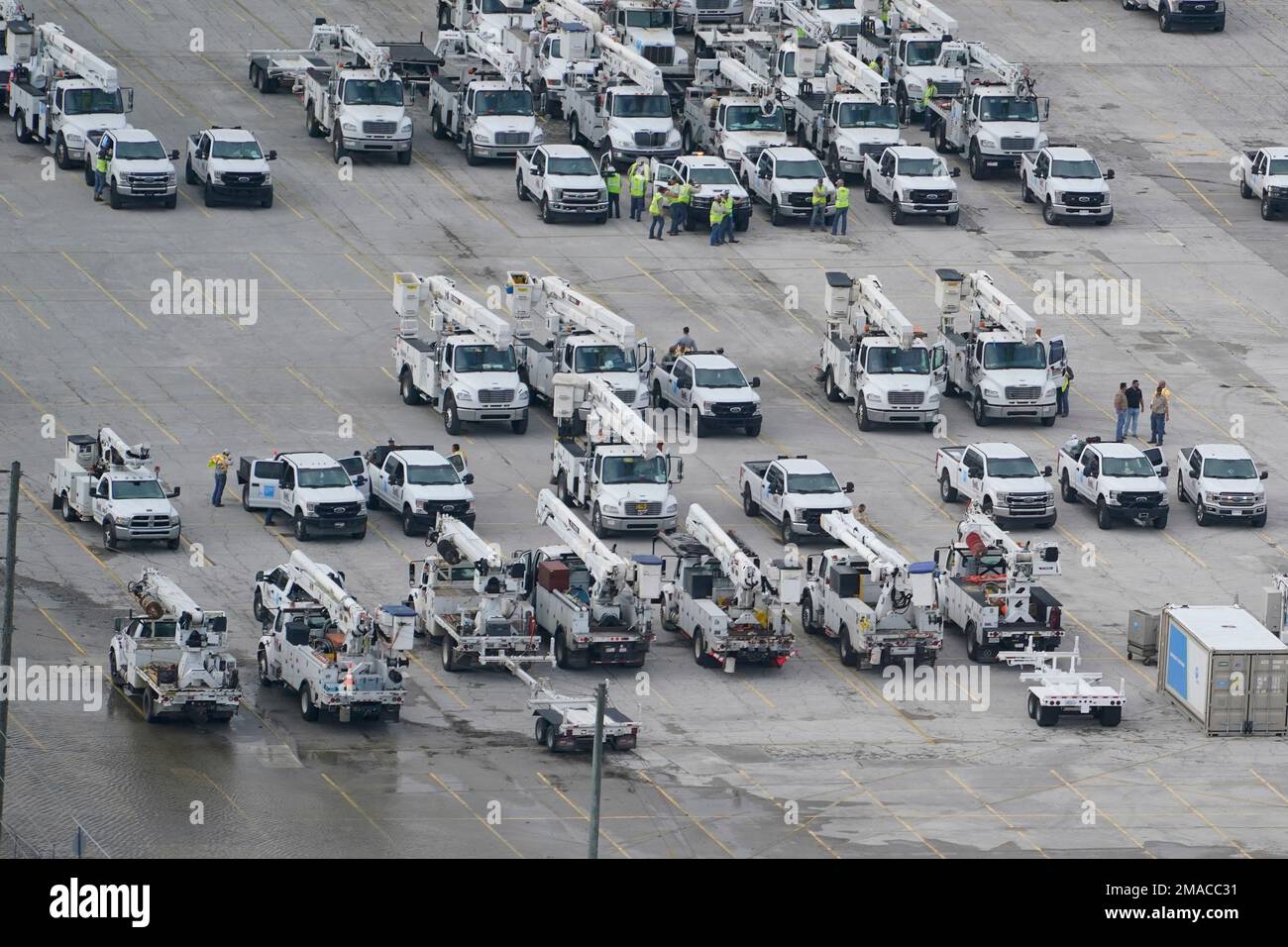 Electrical workers stage in a lot in the aftermath of Hurricane Ian