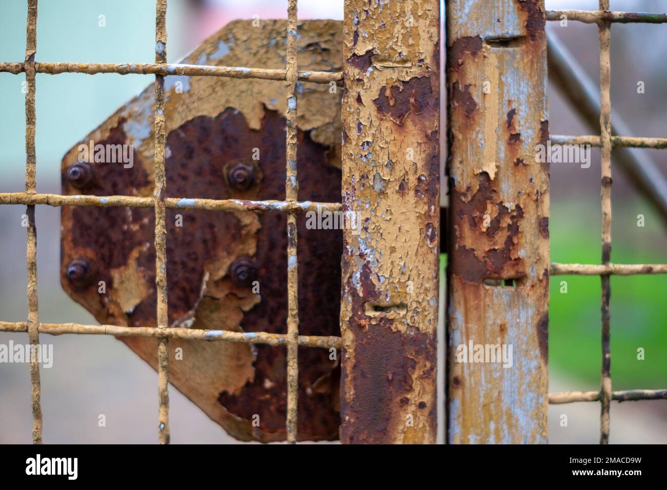 A closeup shot of a rustic metal fence against a blurred background ...