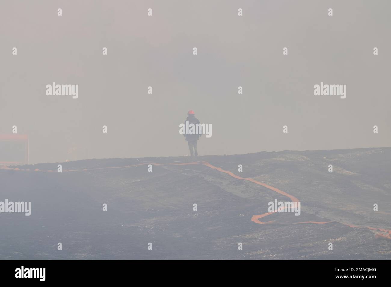 A firefighter entering a curtain of fire from the explosion of the oil