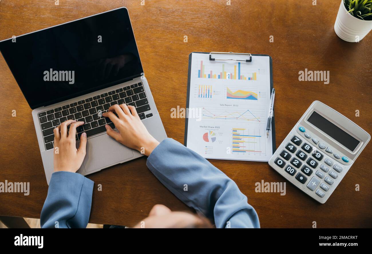 Professional business woman working on laptop computer with chart graphs and calculator Stock Photo