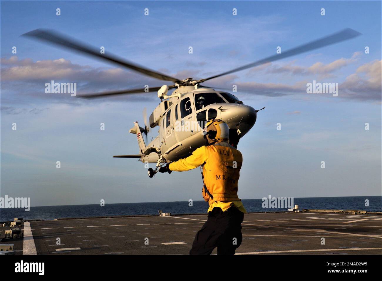 220525-N-EU544-8243 GULF OF THAILAND (May 25, 2022) Boatswain’s Mate 2nd Class David Miller, from Chicago, directs a Royal Thai Navy Sikorsky S-76B helicopter during cross-deck landing qualifications on the flight deck aboard the Independence-variant littoral combat ship USS Jackson (LCS 6) during Cooperation Afloat Readiness and Training (CARAT) Thailand 2022. CARAT Thailand is an annual bilateral naval exercise between the U.S. Navy and Royal Thai Navy. Thailand has been part of the CARAT exercise series since 1995. Now in its 28th year, the CARAT series comprises multiple multinational exer Stock Photo