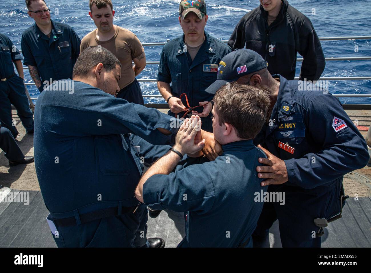220525-N-AO868-1113 MEDITERRANEAN SEA (May 25, 2022) (Left to right) Personnel Specialist 1st Class Gervin Pimentel, Operations Specialist 3rd Class Bailey Byrd and Chief Master at Arms Travis Alston, practice using mechanical advantage control hold (MACH) take down maneuvers, during an antiterrorism training team evolution on the fan tail of the Ticonderoga-class guided-missile cruiser USS San Jacinto (CG 56), May 25, 2022. San Jacinto is on a scheduled deployment in the U.S. Naval Forces Europe area of operations, employed by U.S. Sixth Fleet to defend U.S., Allied and Partner interests. Stock Photo