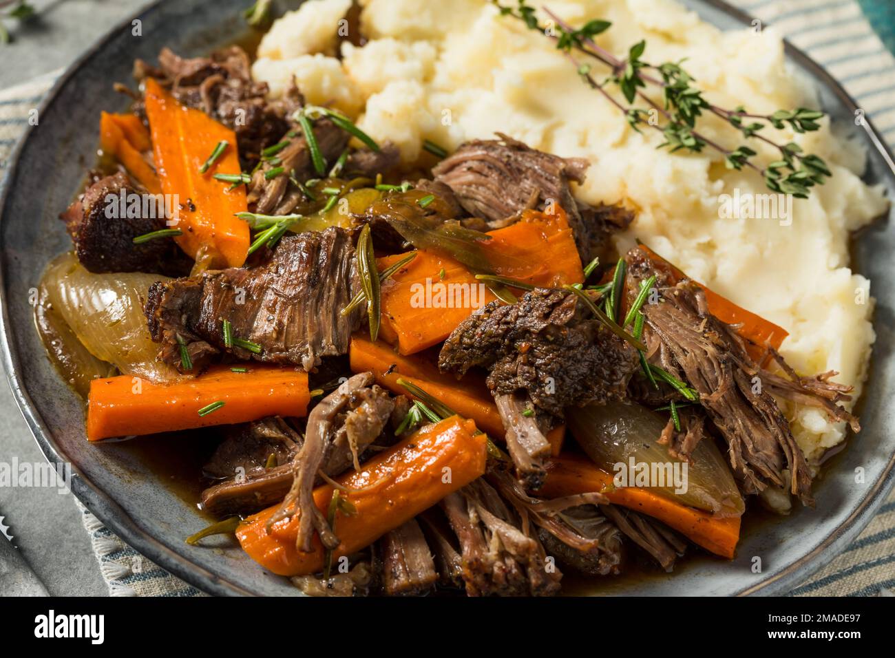 homemade-beef-pot-roast-with-carrots-and-mashed-potatoes-stock-photo